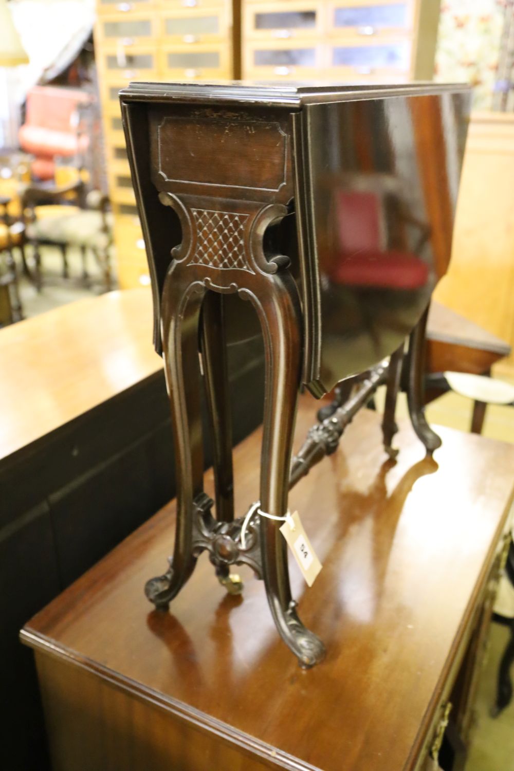 A late Victorian mahogany Sutherland table with shaped top on carved underframe, width 63cm depth 17cm height 59cm